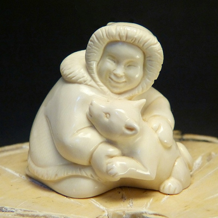Inuit mit Husky spielend